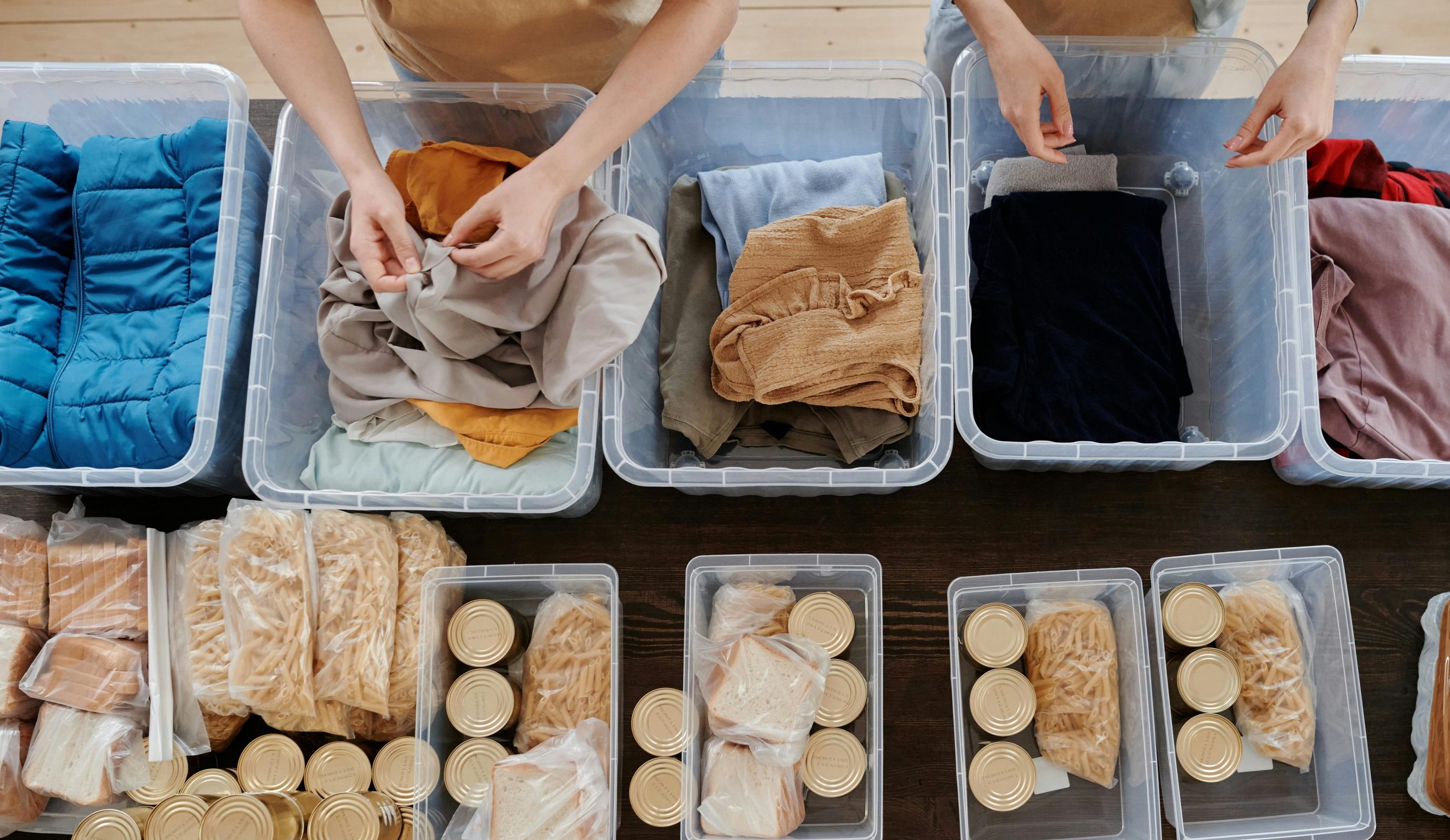 Overhead shot of charity packing food and clothes in bins